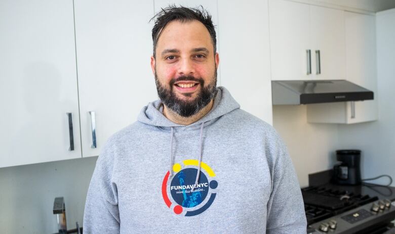 Leonardo Uzcategui stands in a hoodie with the Fundavenyc logo, the organization he runs. 