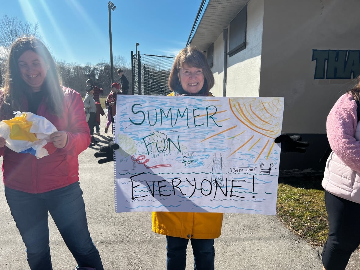 A Londoner holding a sign that says "Summer fun for everyone" 