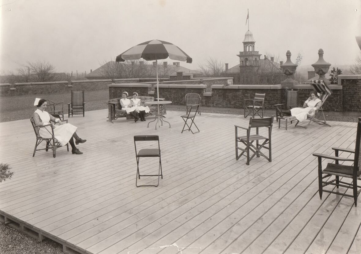 black and white photo of nurses on chairs on a roof patio 