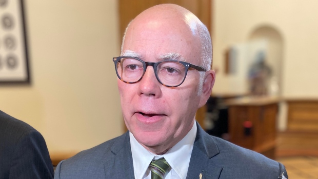 David Coon calls for changes to Fredericton ER after 'pandemonium' over holidays; A balding man with glasses is speaking inside the legislature\.