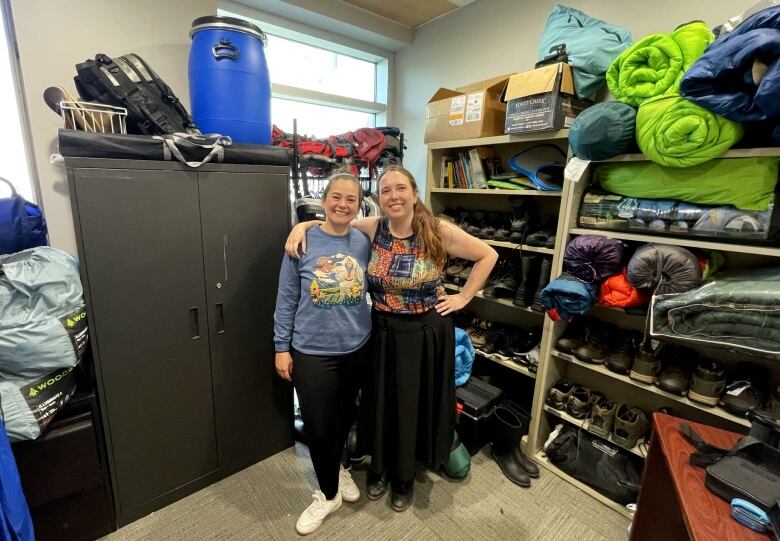 Two girls in a storeroom.