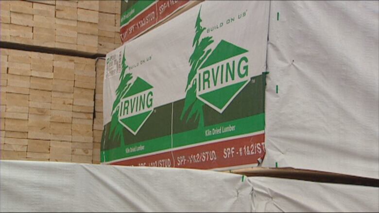 A sign with a tree symbol and the Irving logo next to a pile of wood