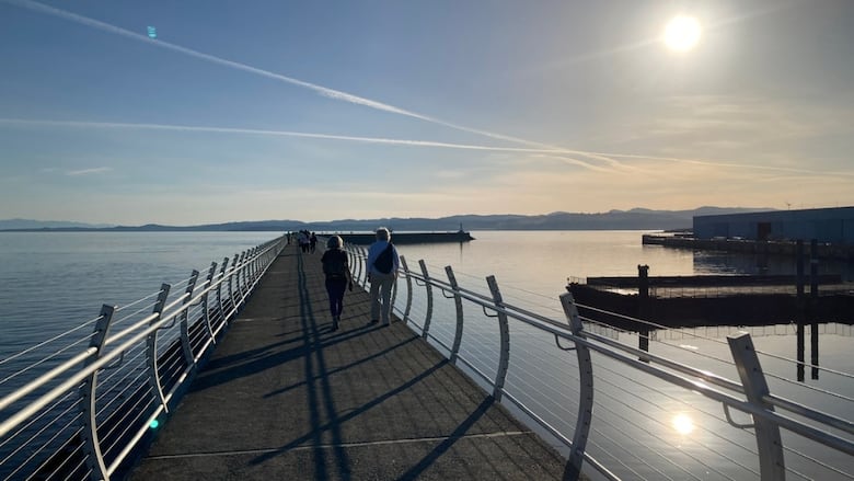 People walking on a breakwater.