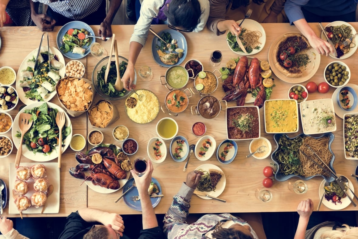 Birdseye view of a table full of food and people around it enjoying it