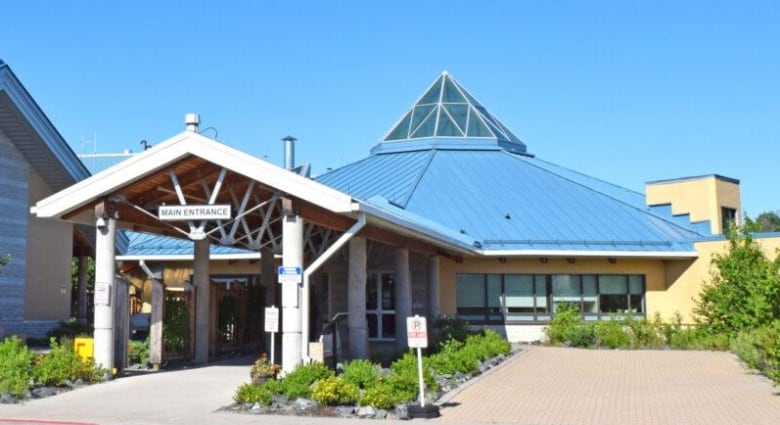 The exterior of a building with a dome-shaped roof, topped with a glass pyramid.