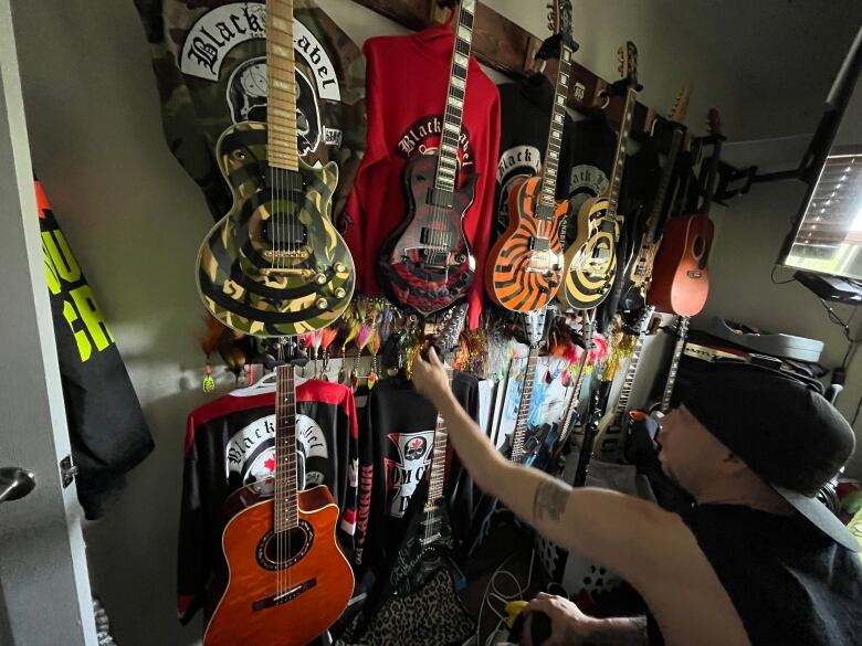 A man reaches for a guitar.