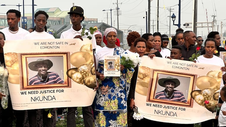 A crowd holds signs calling for justice for Rukinisha Nkundabatware.