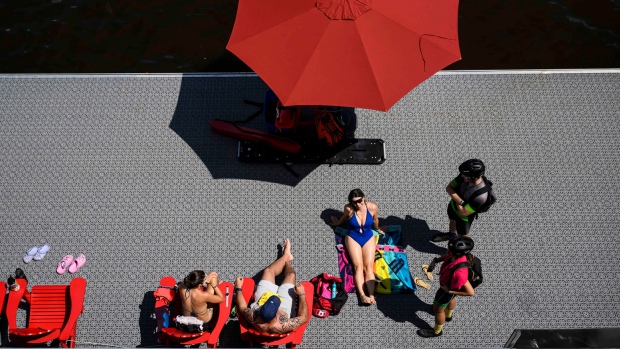IN PHOTOS: This week's most compelling Canadian images; People sunbathe on a dock along the Ottawa River at the NCC River House on the first weekend of its reopening, in Ottawa, Sunday, July 30, 2023\. The heritage building, built between 1914 and 1925, has been fully renovated with an enclosed swimming area\. 