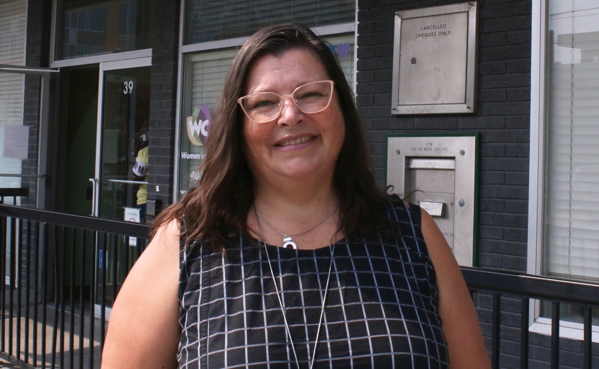 The federal housing advocate smiles in front of the Women's Centre of Calgary's front doors.