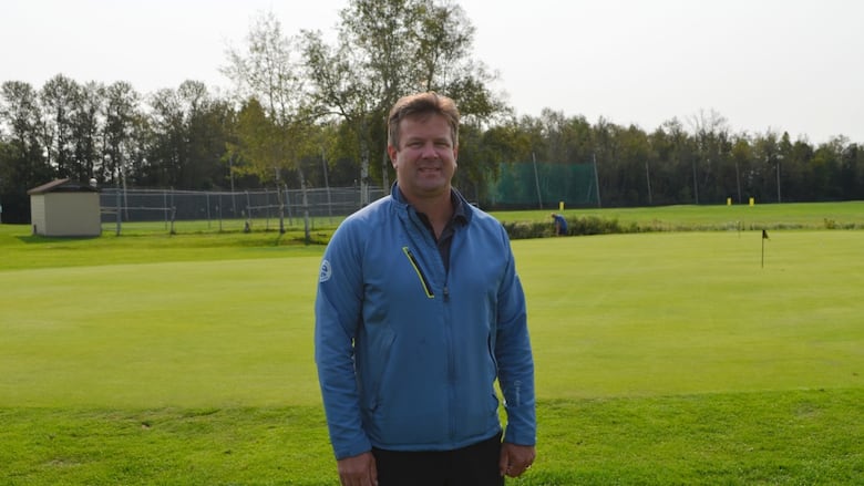 A man stands on a golf course.