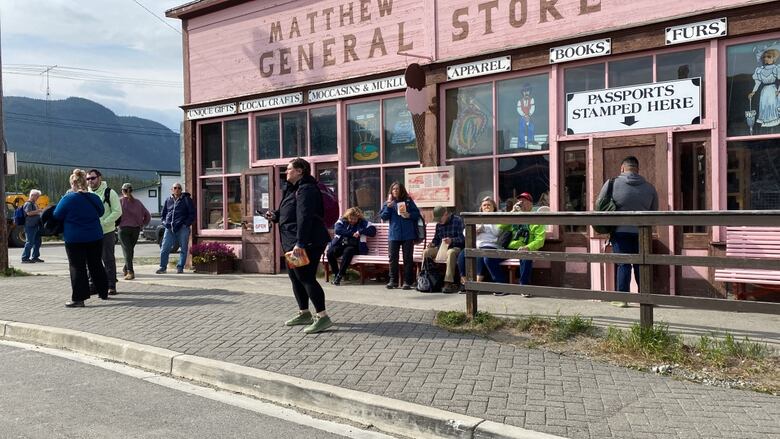 People are shown congregating outside a store that has a sign that reads "General Store." 