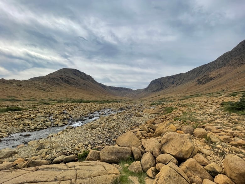 A landscape shot of the Tablelands, featuring orange rocks and spring water.