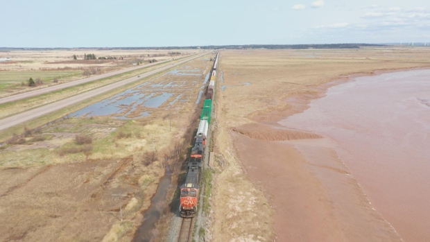 Acadian groups want a Chignecto Isthmus national park; A freight train moves along the CN rail line over the Chignecto Isthmus with the four-lane Trans-Canada Highway on the left\. 