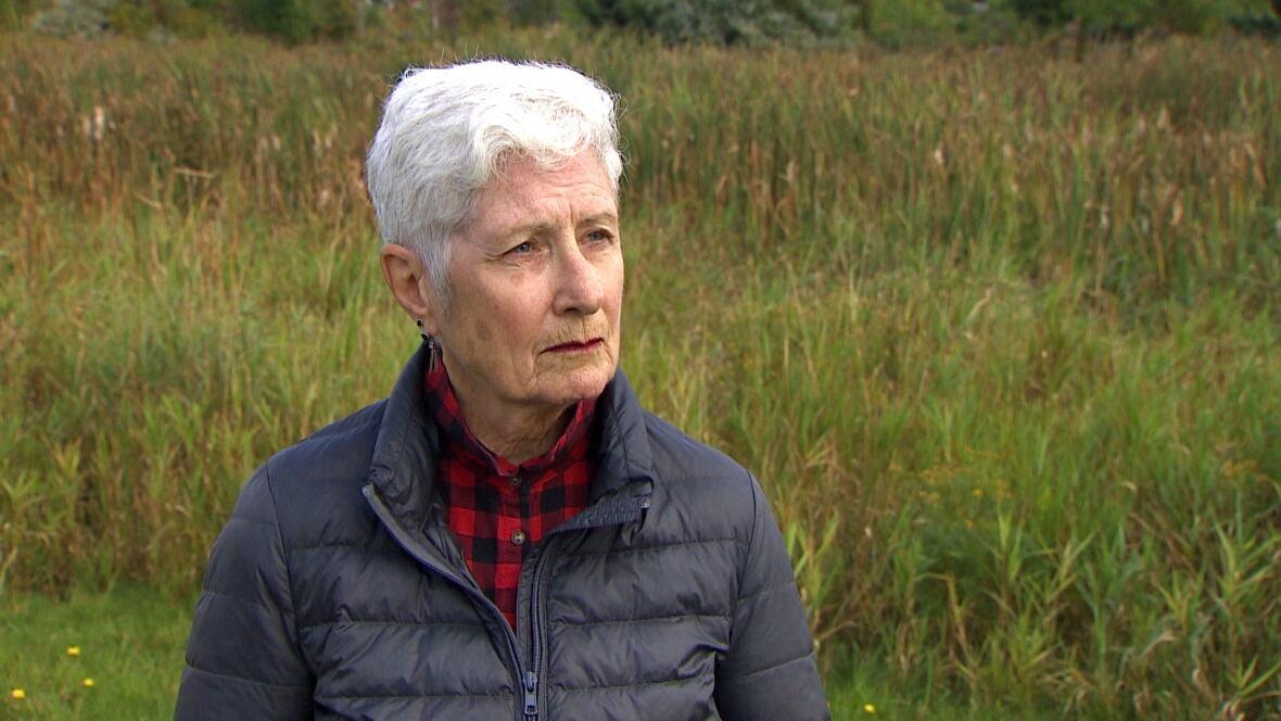 A woman looks with a blank face off camera. 