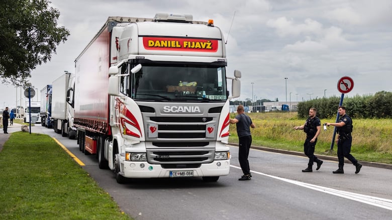 Police approach a transport truck.