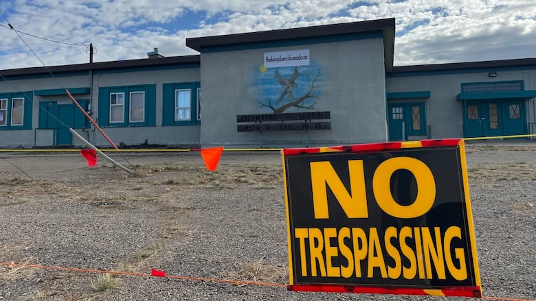 A no tresspassing sign in front of a school. 