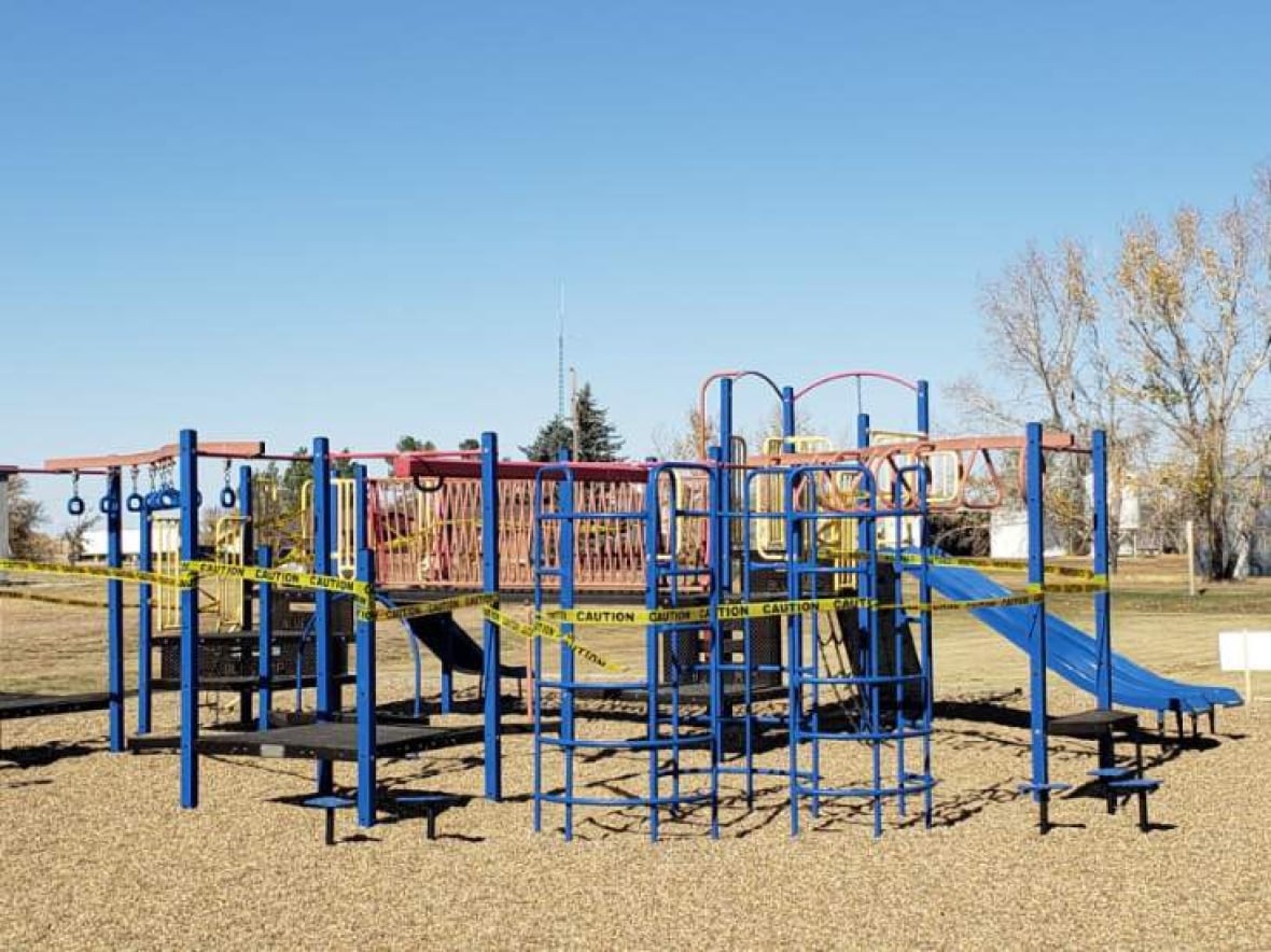 A playground covered in yellow tape.