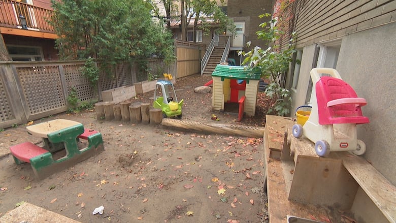 An empty yard behind a daycare filled with toys.
