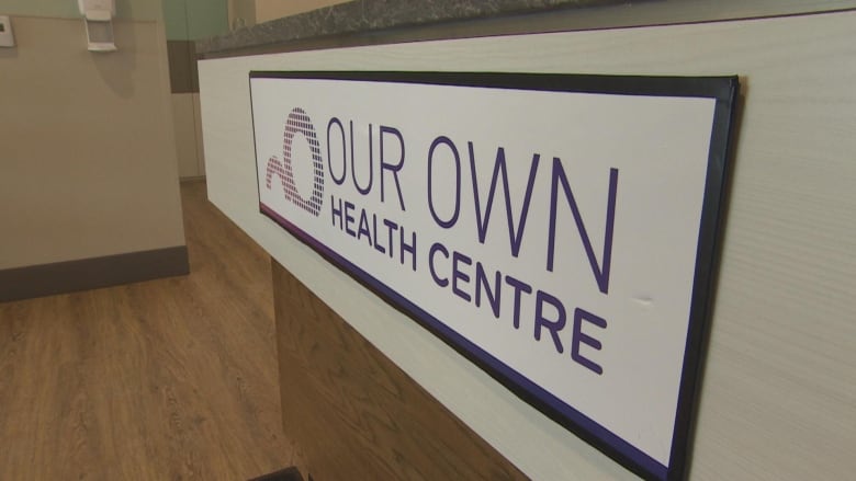 A sign reads 'our own health centre.'