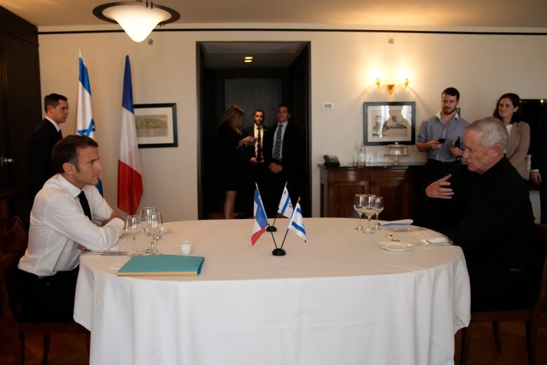 Two men sit at opposite ends of a conference table.