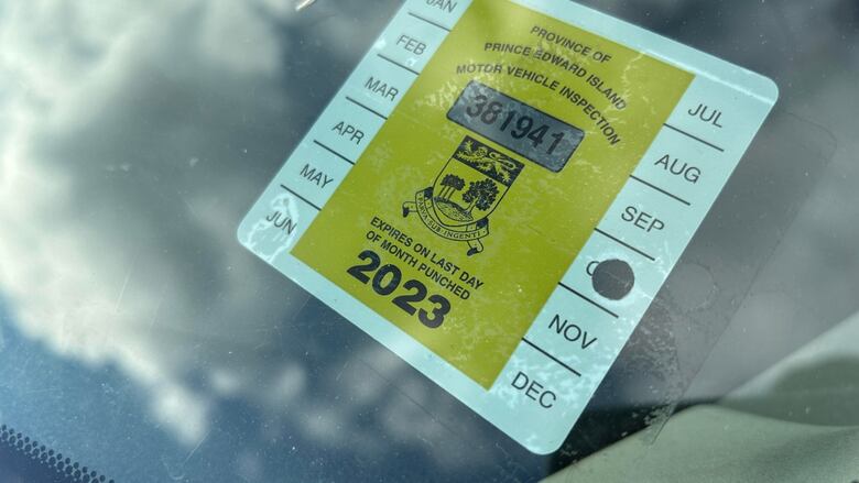 A yellow and white PEI motor vehicle inspection sticker for the year 2023.
