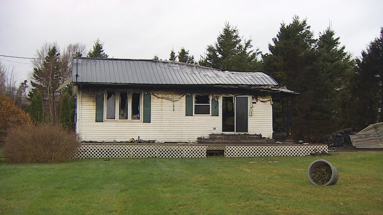 White cottage with fire damage.