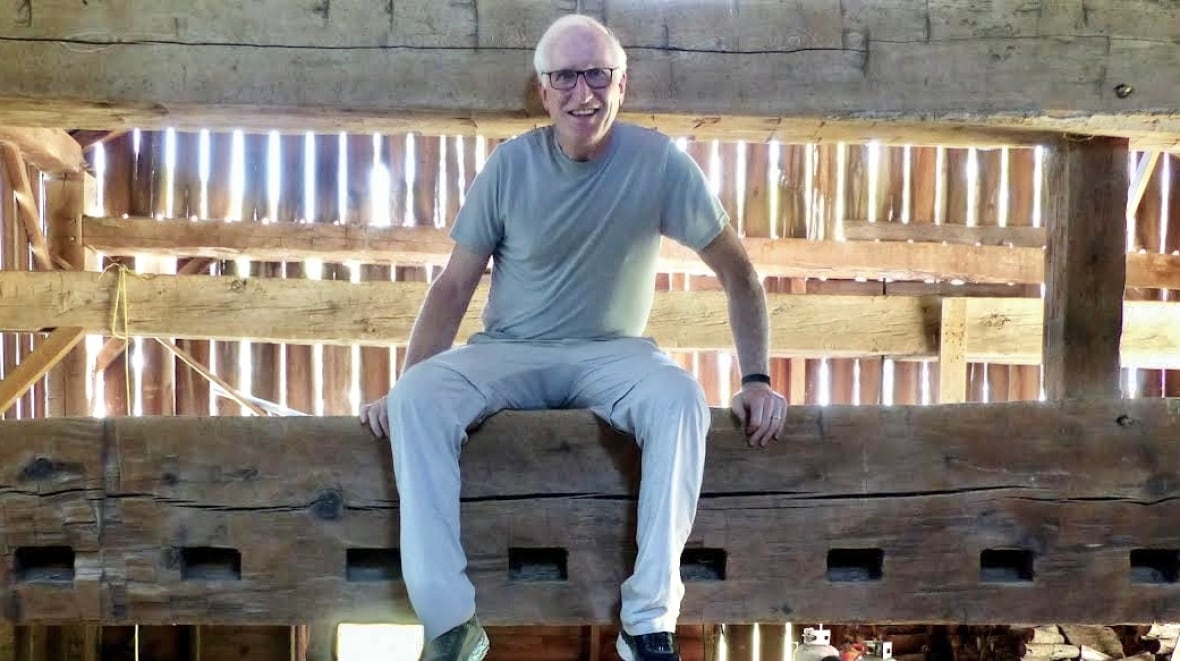 man sits on barn beams