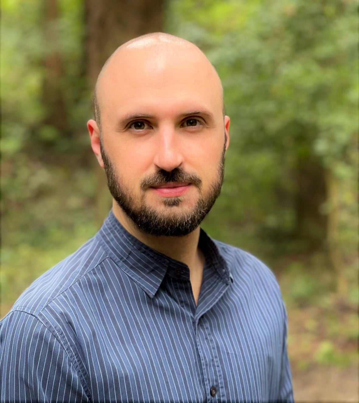 A bald man in a blue shirt.