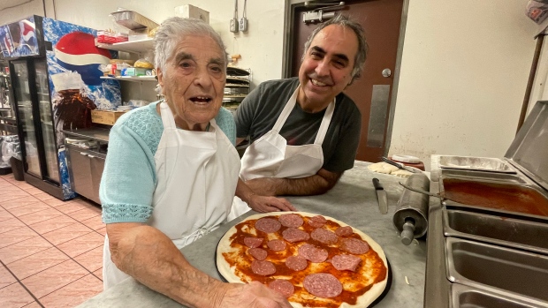 Winnipegger celebrates 100th birthday and makes another pizza; Antoinetta Lomonaco works on a pizza at the Caboto Centre, where her 100th birthday was celebrated, while her son Gerry enjoys her company\.