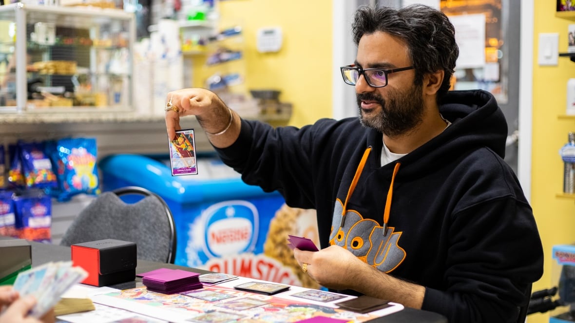 A man holds up a trading card.