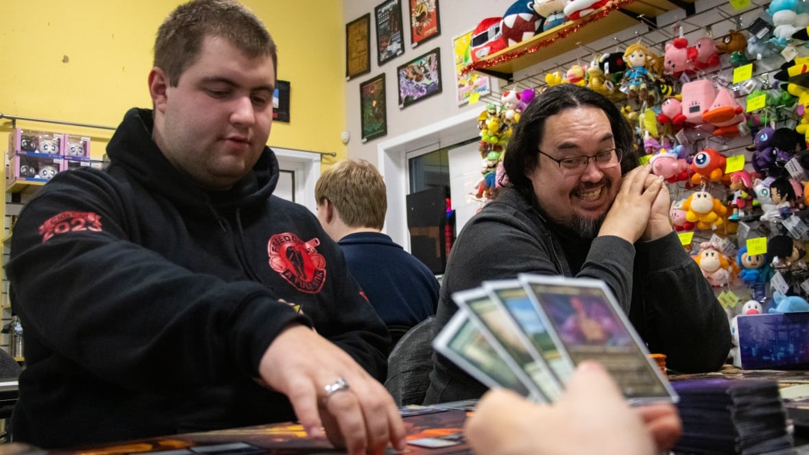 A group of people play card games.