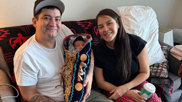 'This little guy is amazing': Proud parents show off Shëth La, N.W.T.'s 1st baby of 2024; Shonto Noeldeke-Catholique \(left\) and Kristen Kodakin-Yakeleya \(right\) had their first child, Shëth La \(centre\), in Yellowknife on Jan\. 3, 2024\. Their baby boy won a prize for being the first child born in the territory in 2024\.