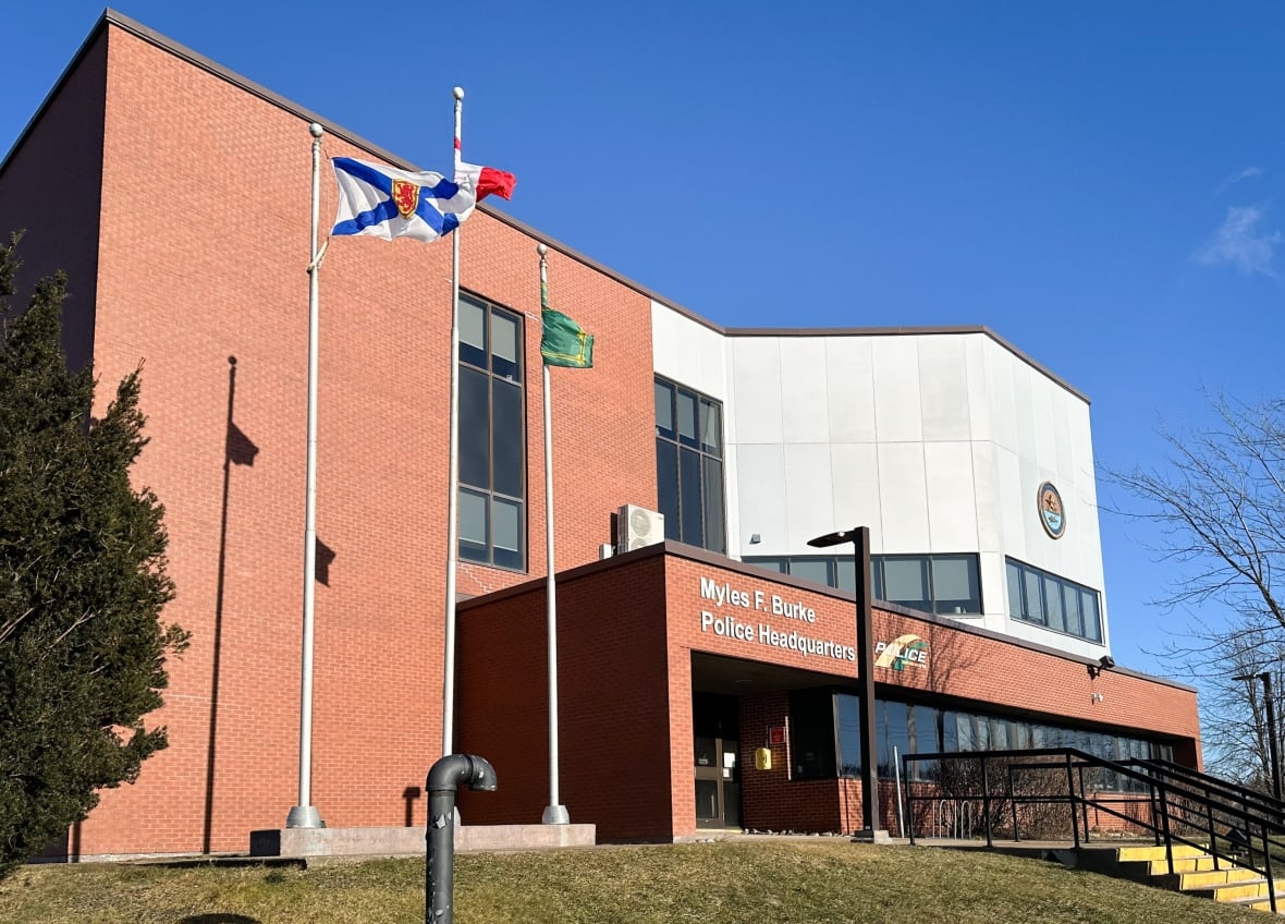 Red brick building with Nova Scotia and Canada flags flying in front.