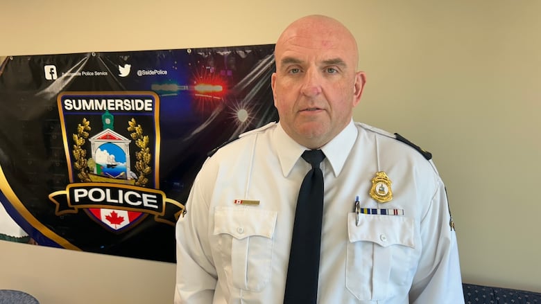 Bald man in white police uniform.