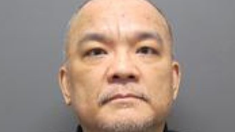A mugshot of a man with a shaved head.