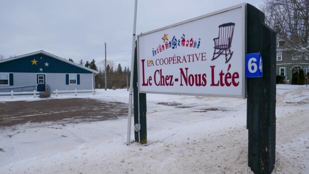 The sign outside Le Chez-Nous community care home in Wellington, P.E.I. Taken Jan. 30, 2024. A sign reading La Cooperative Le Chez-Nous Ltée stands outside a blue building. There is snow on the ground.
