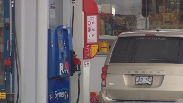 Gas and diesel drop by less than a cent in weekly price setting; A beige van is parked at a gas pump\.