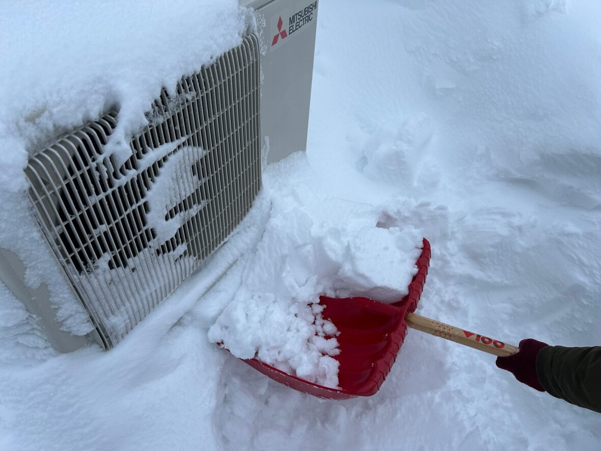 Heat pump being dug out of a snow drift. 