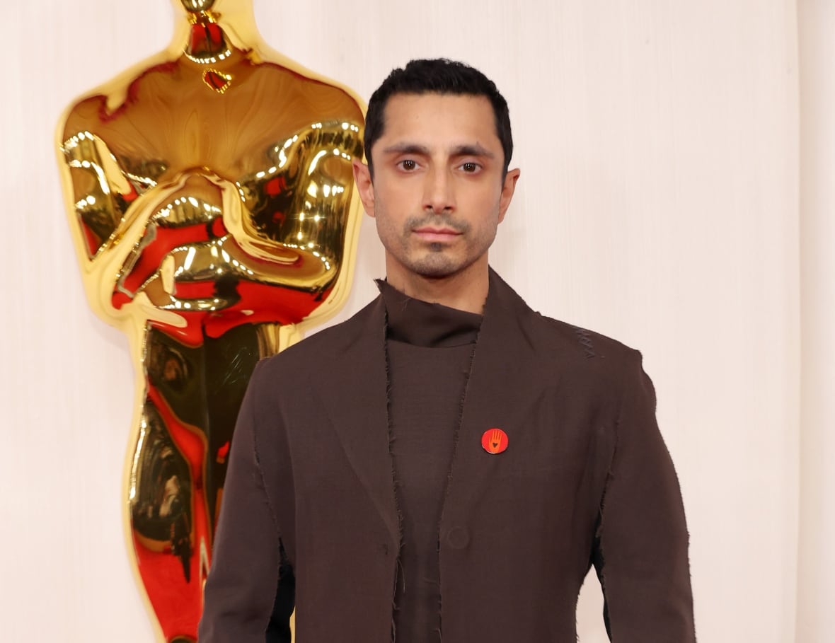 A man wears a brown jacket and matching pants during an event.