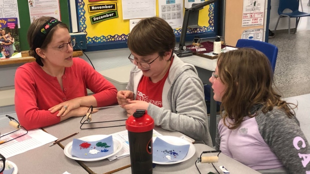 Guelph students among Canadian kids learning math concepts through Métis beading practices; Grade 6 students at St\. John Catholic Elementary School in Guelph working on their bracelets while Métis knowledge keeper Alicia Hamilton helps\.