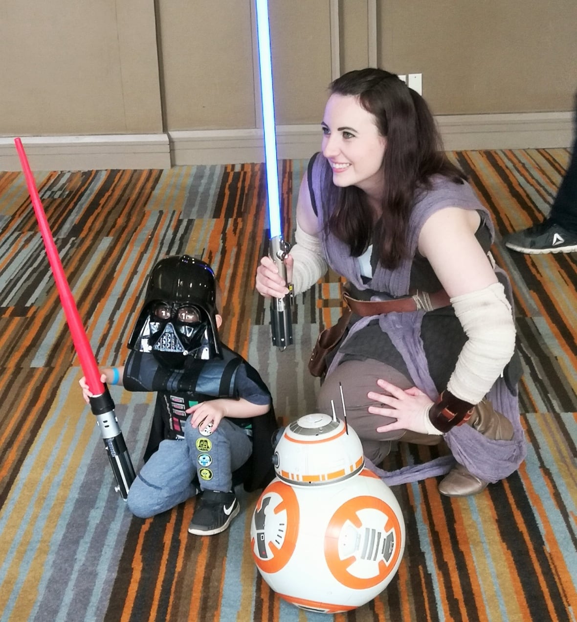 Stephanie Middleton, dresses as Rey from Star Wars, poses for a photo with a small fan.