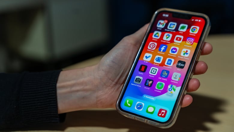 A hand holds an iPhone.