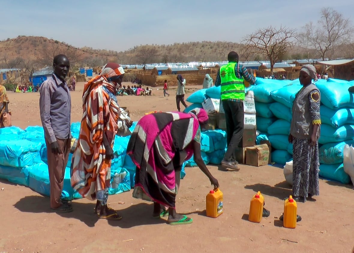 A group of refugess gather to recieve food from aid workers.