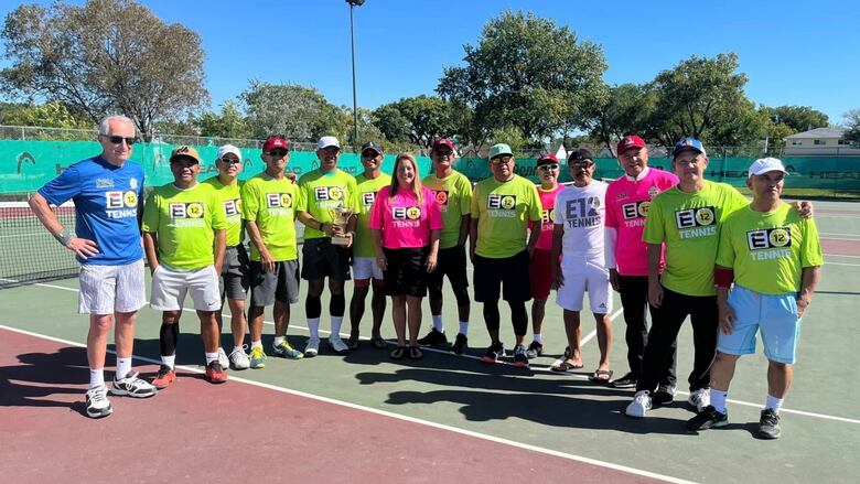 People stand on a tennis court.