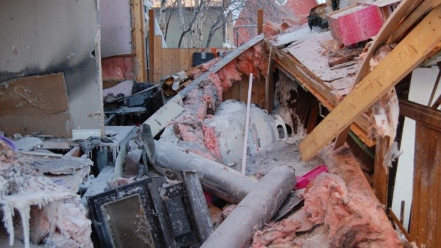 N.W.T. homes damaged in 2022 explosions both had gas work done without permits; A photo from the fire investigation report showing the right side of the home on Dagenais Drive in Yellowknife after a propane explosion in December 2022\. A wood stove is seen in the bottom left corner and beyond it — a toppled propane tank from Matonabee Petroleum\.