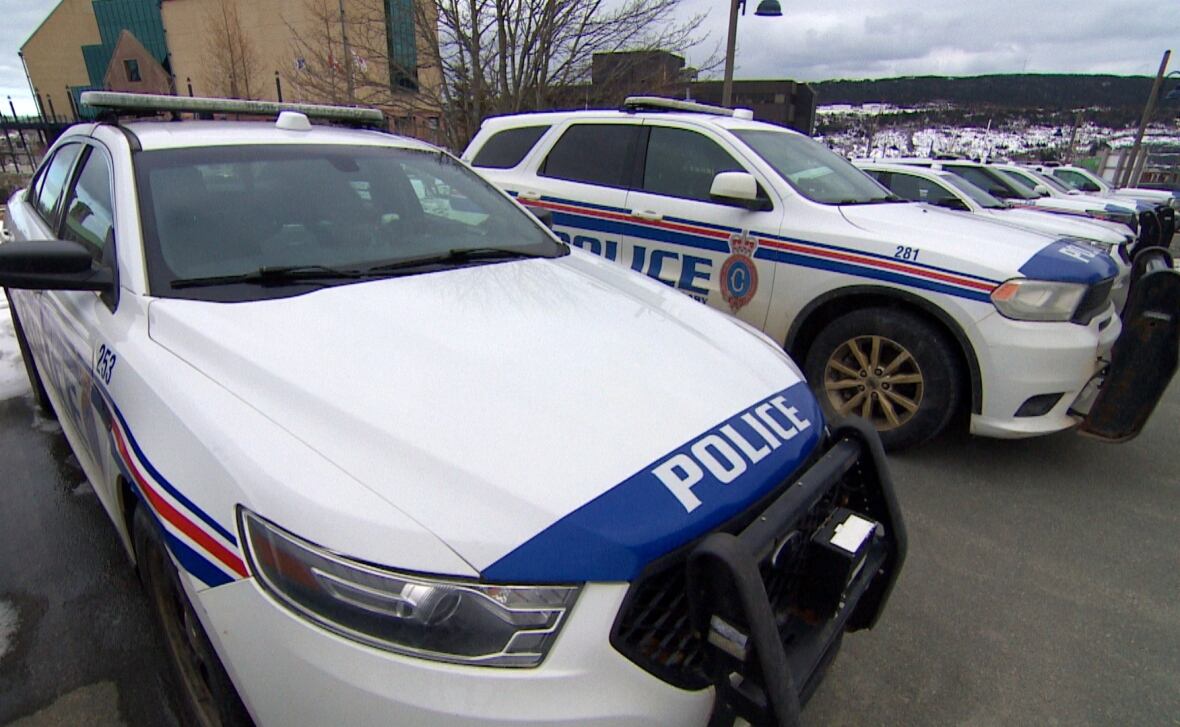Police vehicles are lined up   successful  a enactment      successful  a parking lot. 