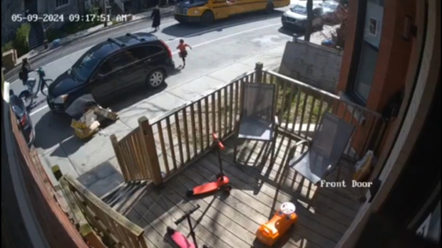 Cyclist fined after hitting child crossing street to catch school bus; This screengrab from a video shared on social media by Mayer Feig shows the moment the young girl crosses the street as the cyclist is approaching\. 