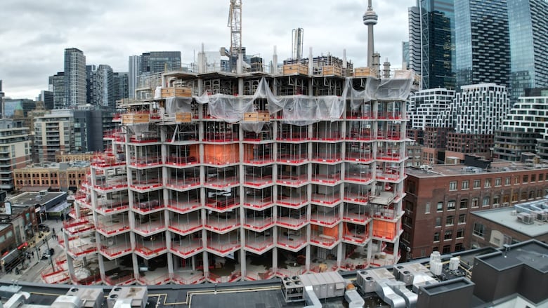 Vista aérea do condomínio em construção com torre CN e horizontes de Toronto ao fundo. 
