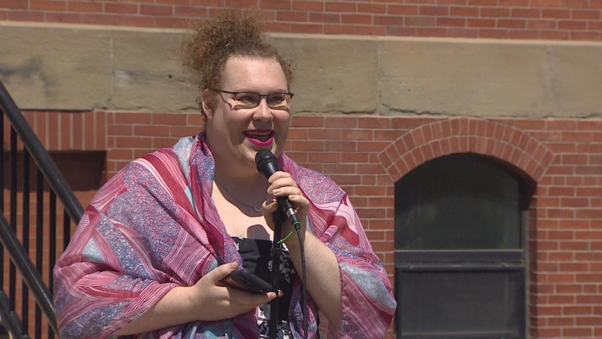 A woman holds a microphone and speaks into it.