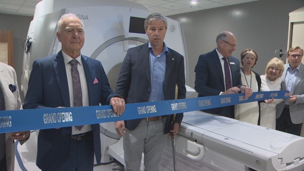 New MRI at Dartmouth General Hospital expected to scan 400 patients a month; Premier Tim Houston used oversized scissors to cut a thick blue ribbon stretched across the imager